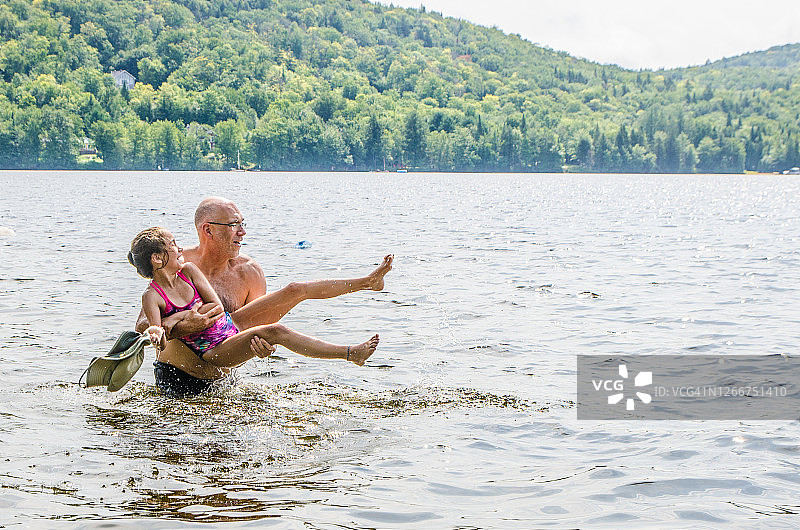 父亲抱着女儿在湖边图片素材
