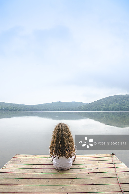 坐在湖边甲板上的小女孩图片素材