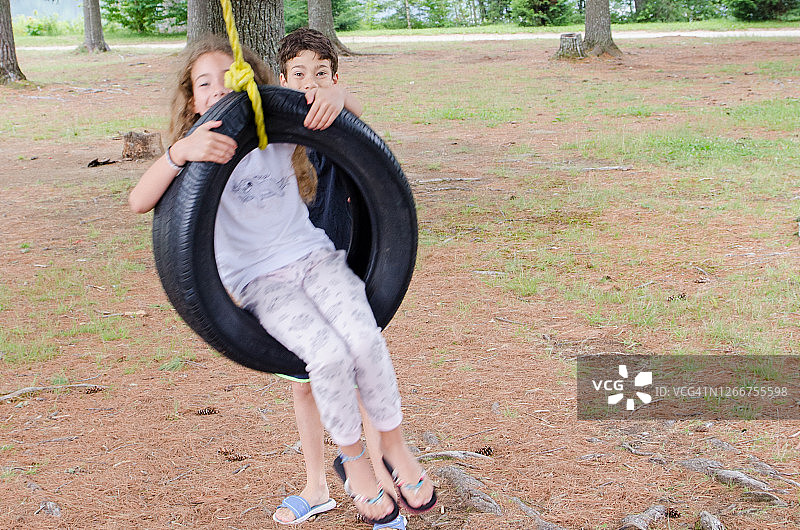 男孩帮助妹妹荡秋千图片素材