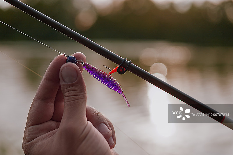 渔夫在日落时分的河边钓鱼图片素材