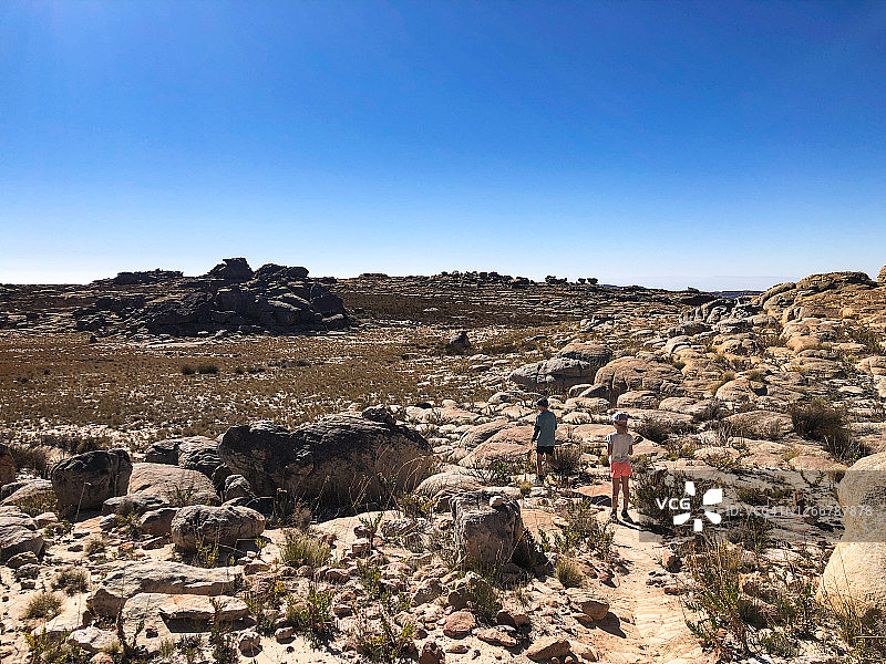 在沙漠山间小路上徒步的男孩和女孩图片素材