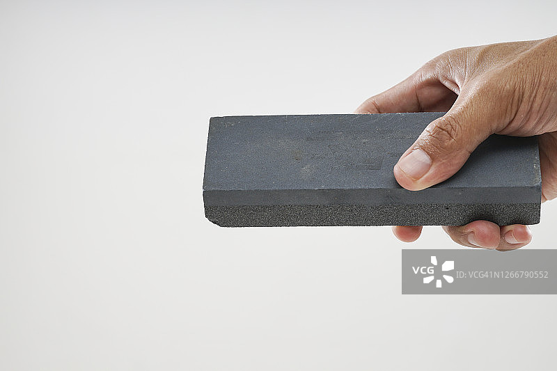 特写镜头下手持磨刀石图片素材