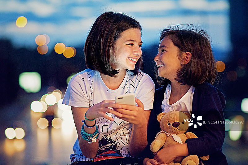 女朋友们在夜晚的桥上玩耍图片素材