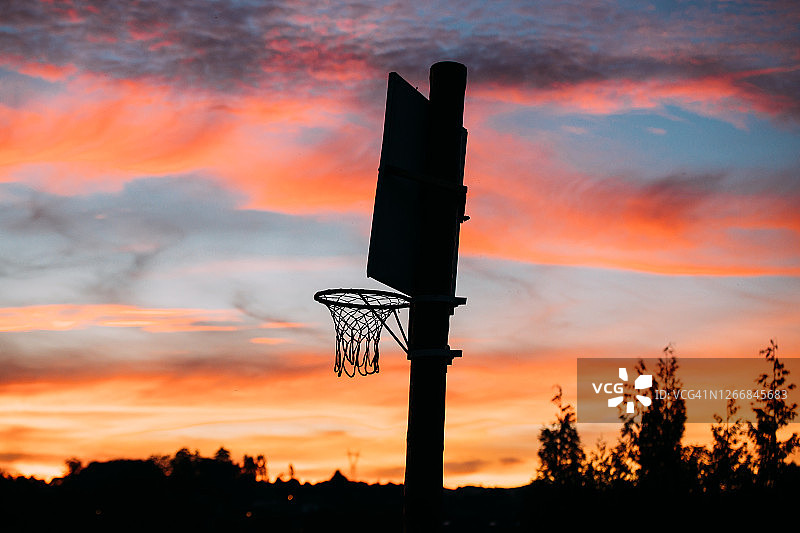 日落时分，橙色天空下的篮球架和篮板图片素材