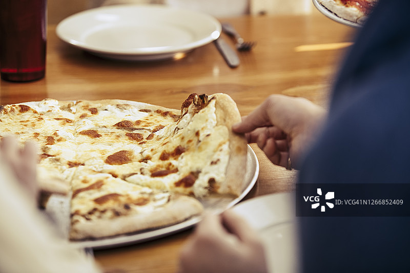 女人抓起一片披萨的特写镜头图片素材