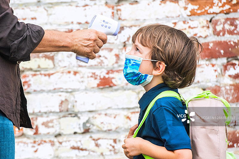 老师为返校儿童测量体温图片素材