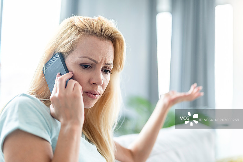 忧心忡忡的中年妇女在打电话图片素材