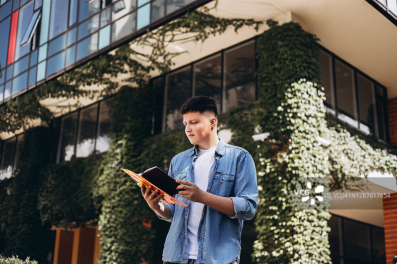 青年男子在街上看笔记本图片素材