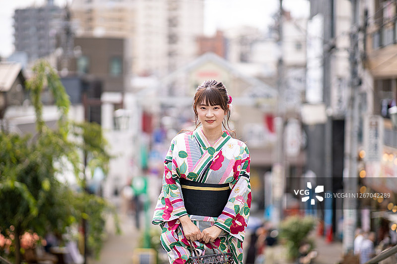 身穿浴衣站在购物街上的年轻女子图片素材