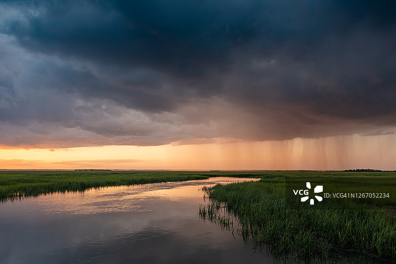 盐沼上逼近的风暴中的日落图片素材