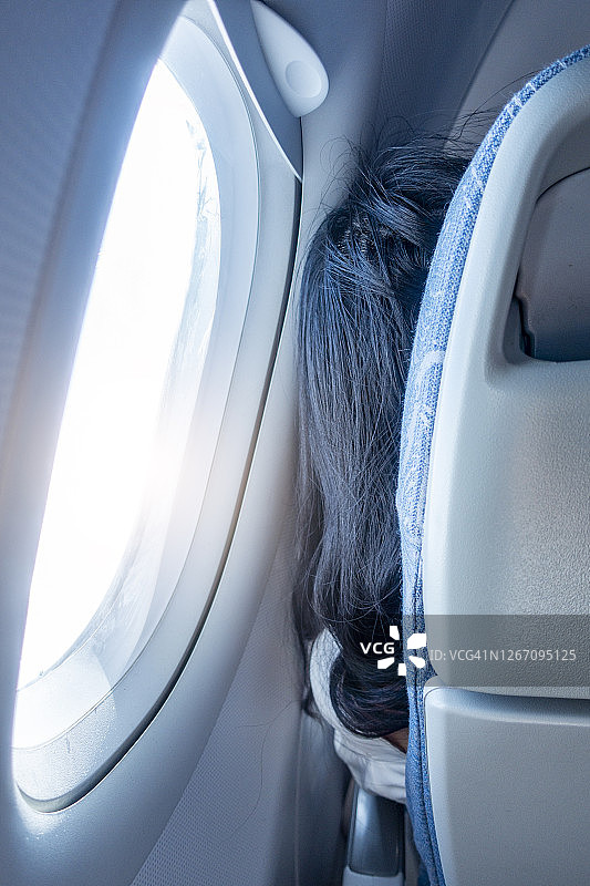 坐在飞机窗边的女人特写图片素材