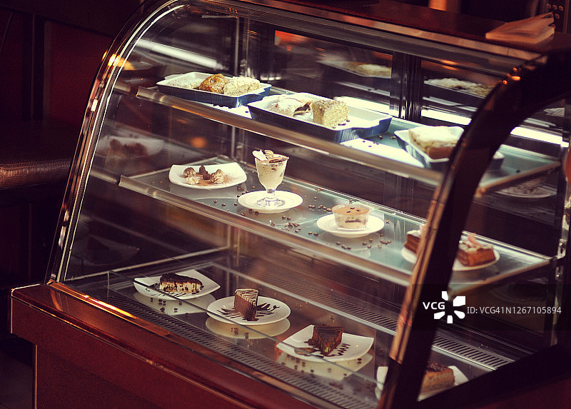 展示各种甜点的橱窗——芝士蛋糕、蛋糕、饼干、羊角面包、马卡龙。小型商业咖啡店图片素材