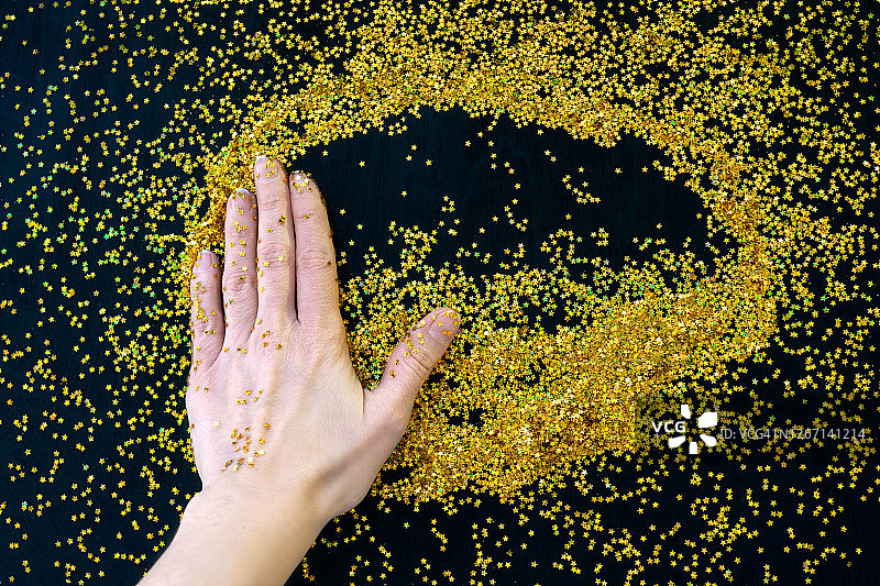 手持飞舞的亮片，浅色背景图片素材