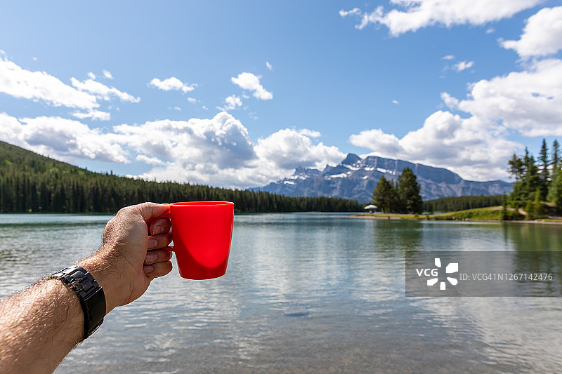 手持咖啡杯拍摄加拿大班夫明尼万卡湖图片素材