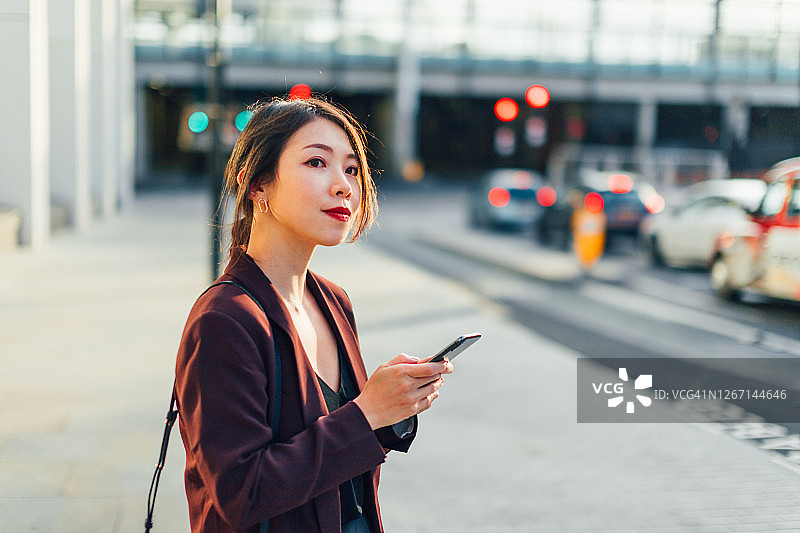 在城市里寻找她的车的亚洲年轻女性图片素材