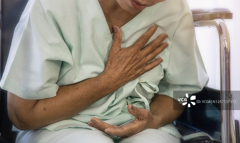老年人心脏病概念：老年女性胸痛难忍，心脏病发作，等待在医院接受医生检查图片素材