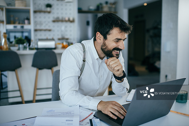 年轻男人在家使用笔记本电脑工作图片素材