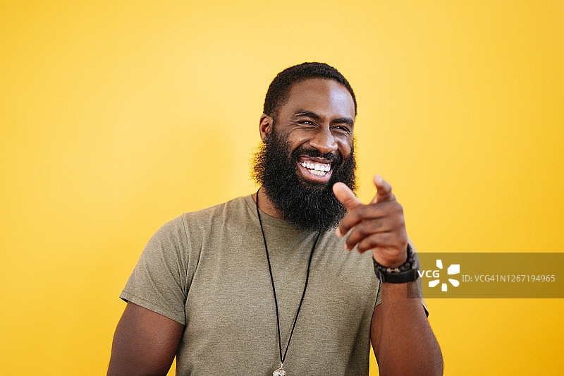 30岁出头的黑人男子在工作室里笑着指点图片素材