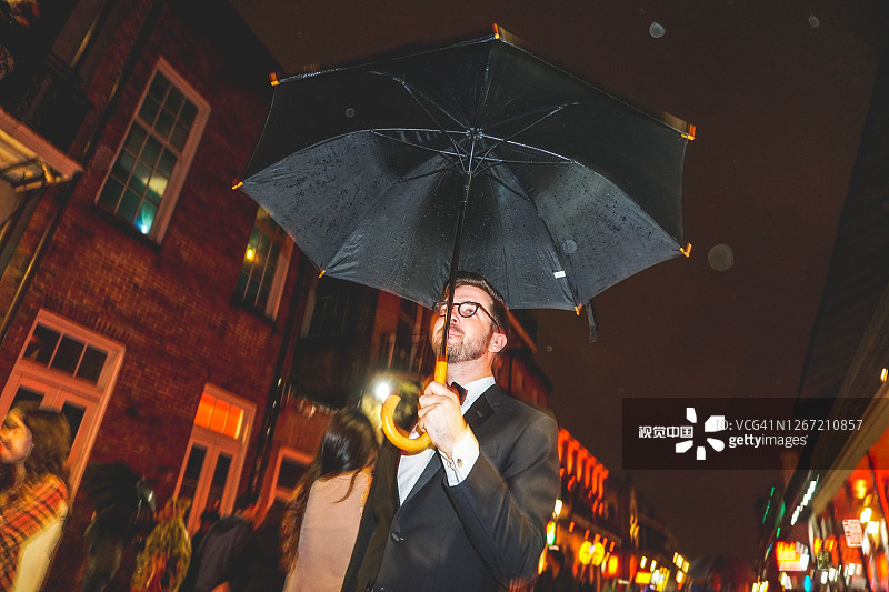 优雅男士手持雨伞吸烟参加派对图片素材