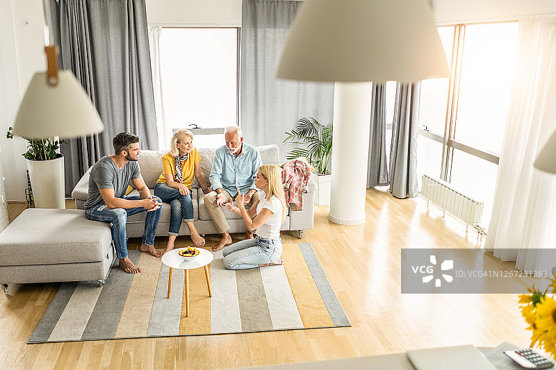 幸福的一家在客厅里坐在一起聊天图片素材