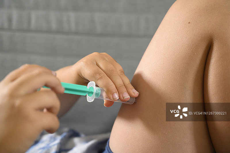 男孩在腿上给自己注射图片素材
