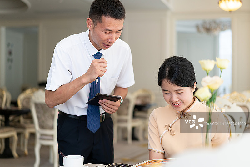 服务员帮助女顾客点餐图片素材