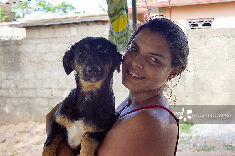 微笑的古巴女人抱着混血犬图片素材