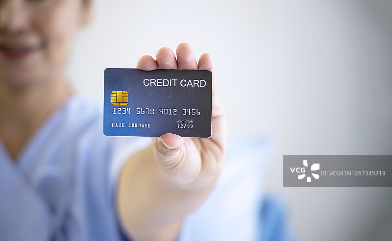 保险概念：医院里的女病人手持信用卡图片素材