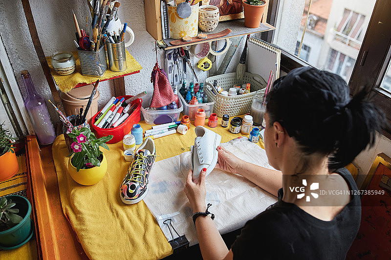 女艺术家在绘画前检查运动鞋图片素材