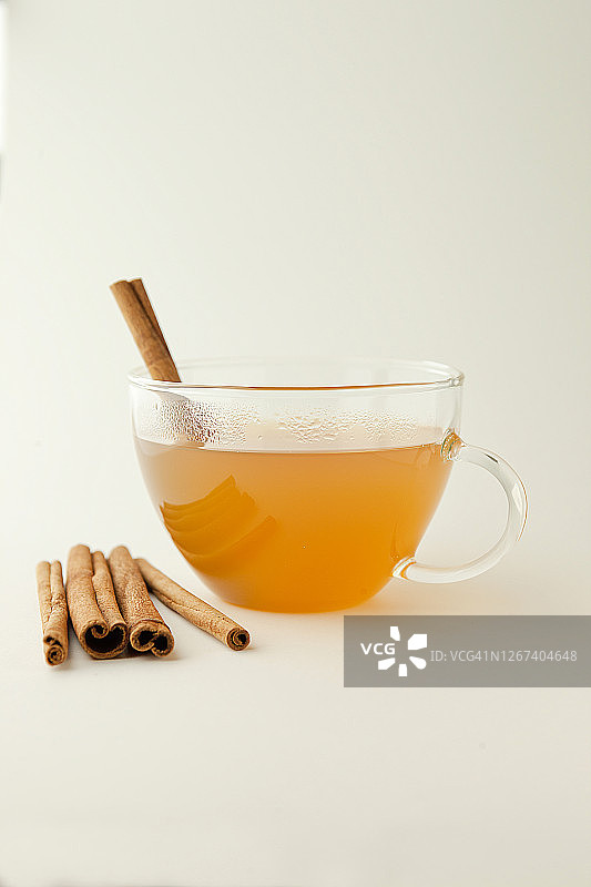 透明玻璃杯中的热苹果酒和肉桂棒图片素材