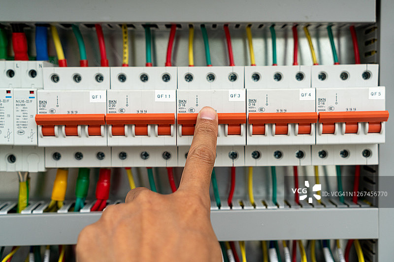 人手拨动电气控制柜中的电源开关图片素材