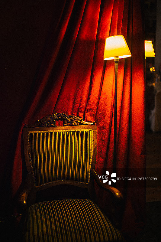 巴洛克风格扶手椅、黄色灯和红色窗帘图片素材