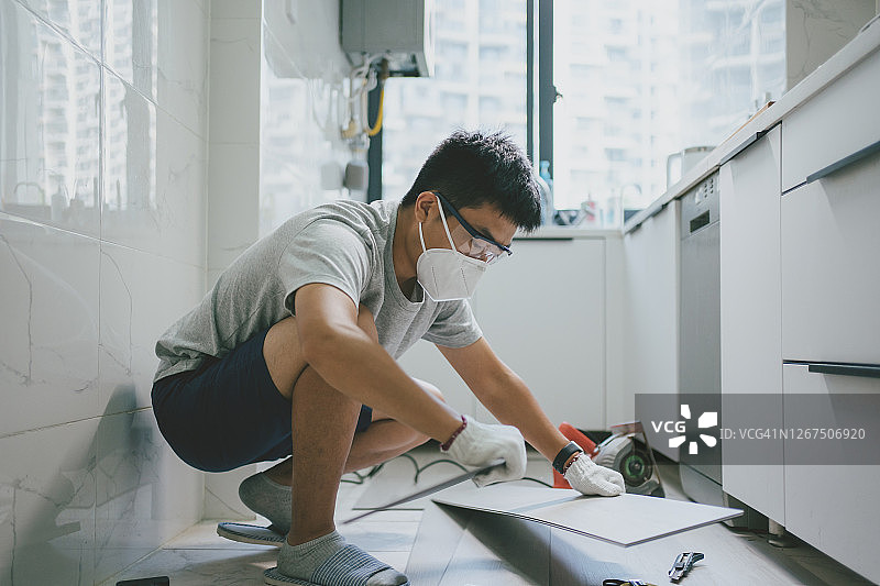 亚洲男人在家中安装强化地板图片素材