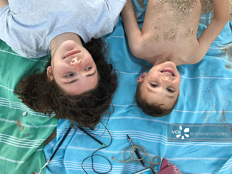 少女和表妹在沙滩的毯子上图片素材