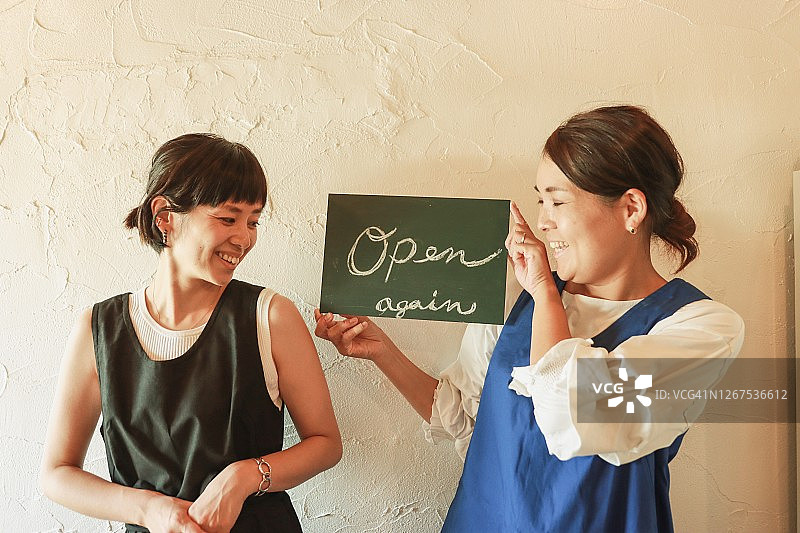 咖啡馆里拿着标牌的快乐店主图片素材