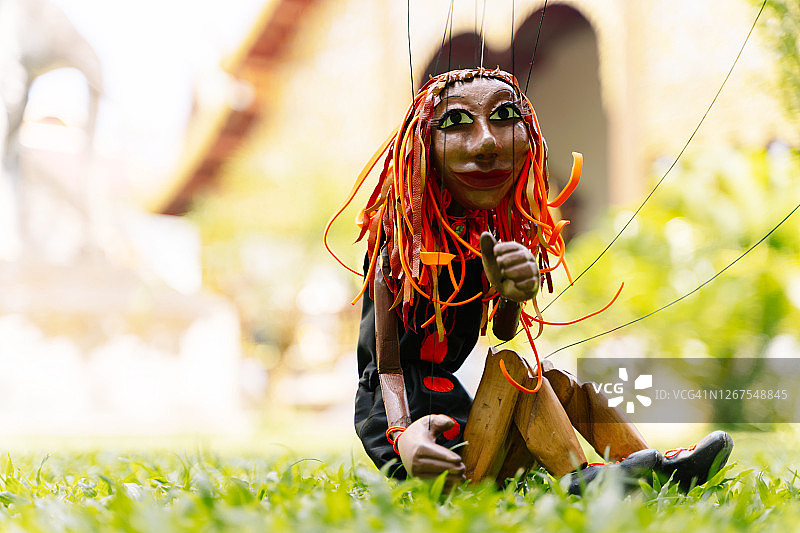 木偶和坐在佛寺前草地上的女人图片素材