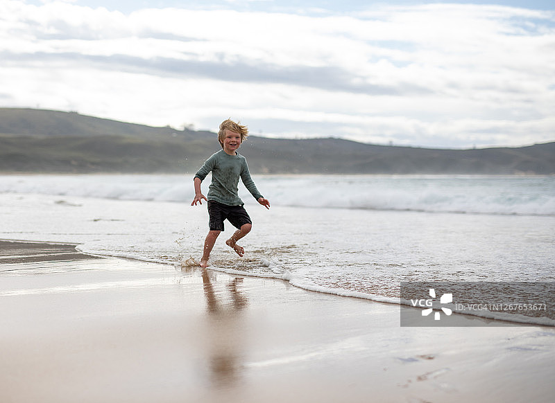 男孩在海滩上奔跑图片素材