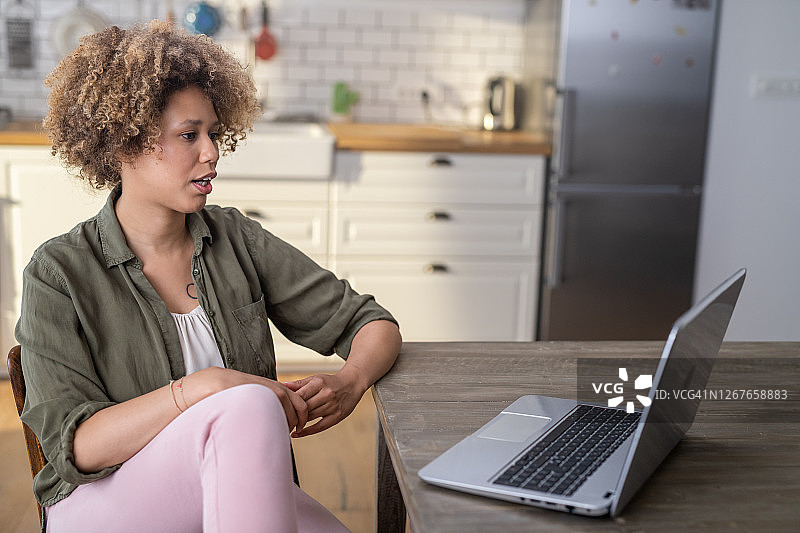 女人坐在厨房里进行视频通话图片素材