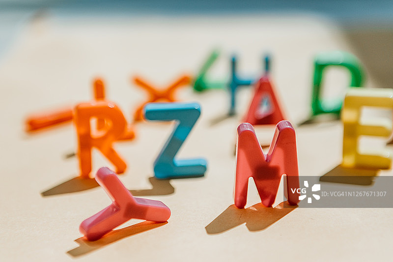 凌乱的塑料大写字母阴影，聚焦字母M图片素材