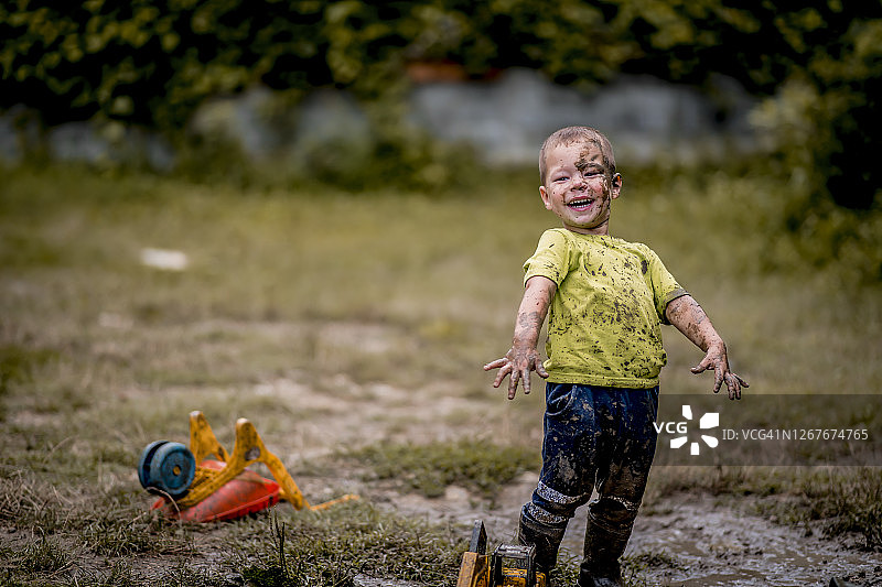 在泥地里玩耍的小男孩图片素材