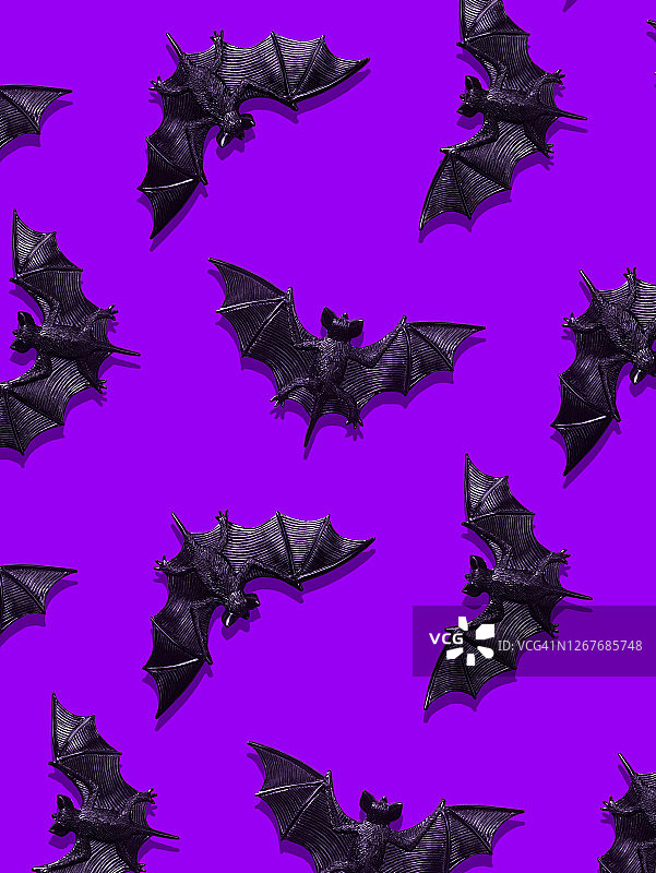 紫色背景上的塑料蝙蝠玩具图片素材