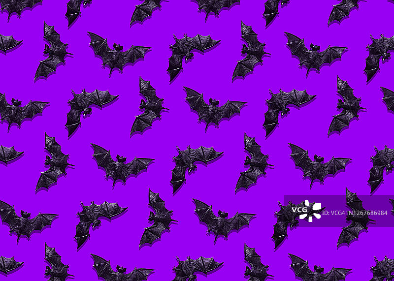 紫色背景上的塑料蝙蝠玩具图片素材