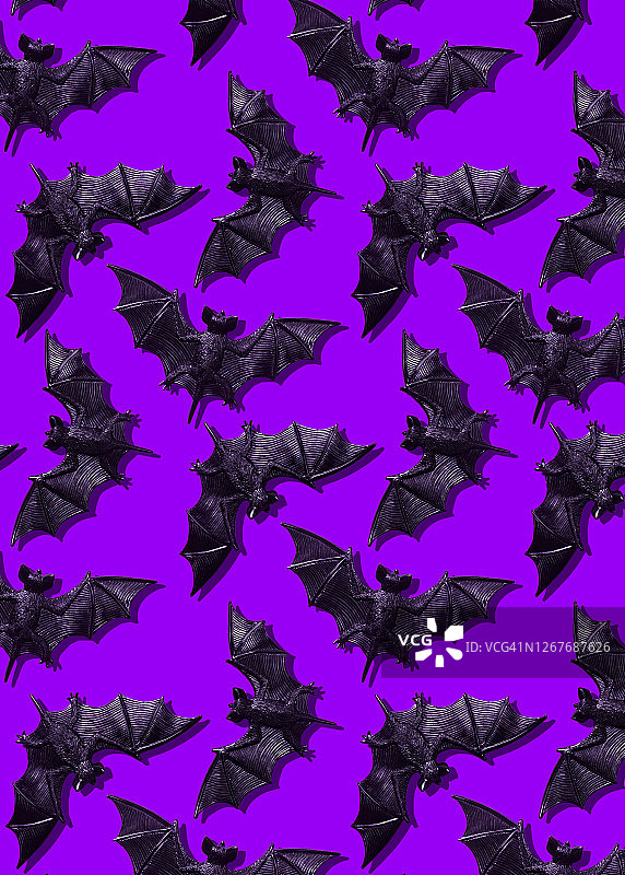 紫色背景上的塑料蝙蝠玩具图片素材