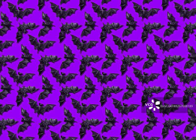 紫色背景上的塑料蝙蝠玩具图片素材