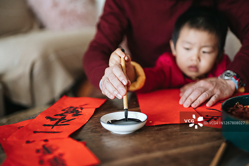 爷爷练习书法写春联，教孙子写字的特写图片素材