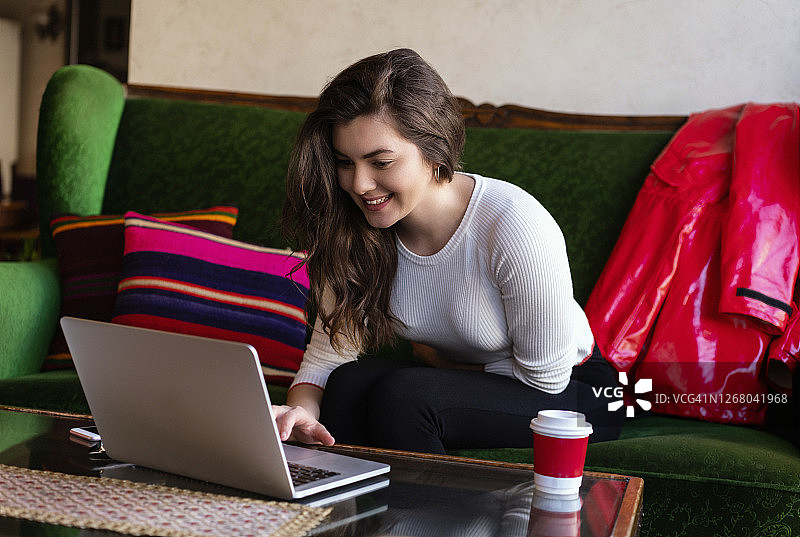 年轻女人在土耳其伊斯坦布尔的一家咖啡馆工作时使用笔记本电脑图片素材