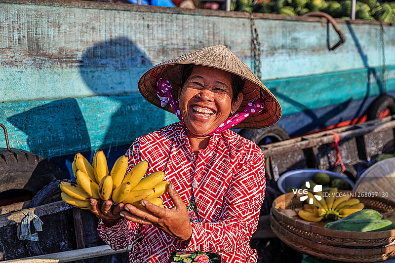 越南女人在湄公河三角洲水上市场售卖香蕉图片素材
