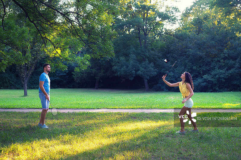 情侣在公园里打羽毛球图片素材