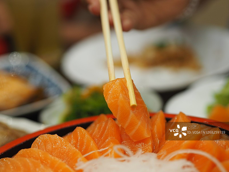 用筷子夹三文鱼日式料理图片素材