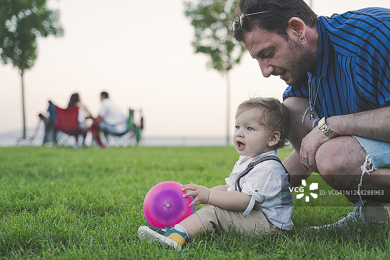 在公园和父亲踢足球的男婴图片素材